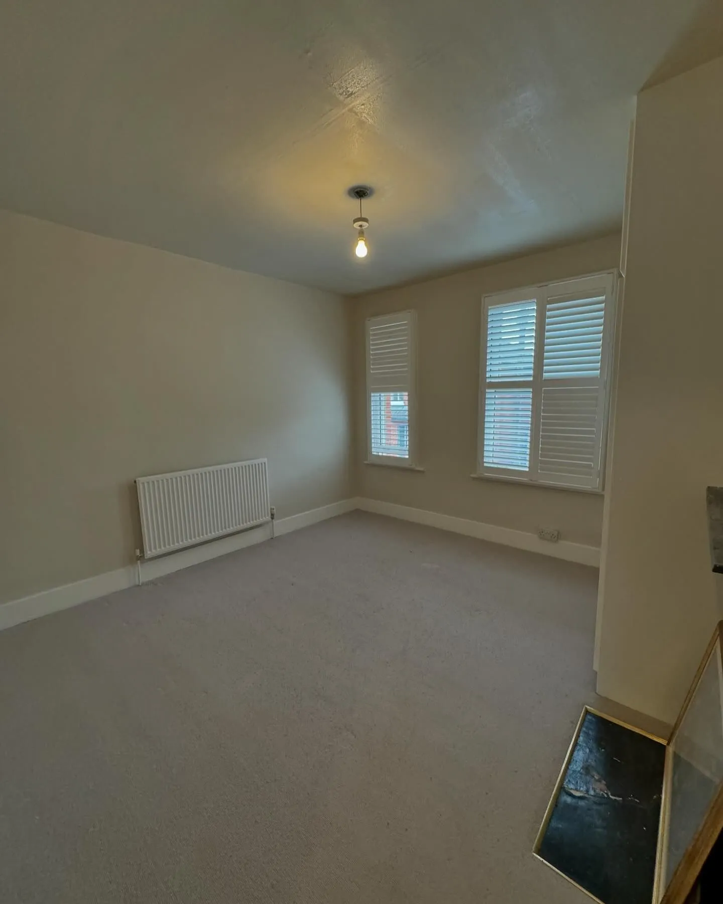 An empty room with a radiator and a window.