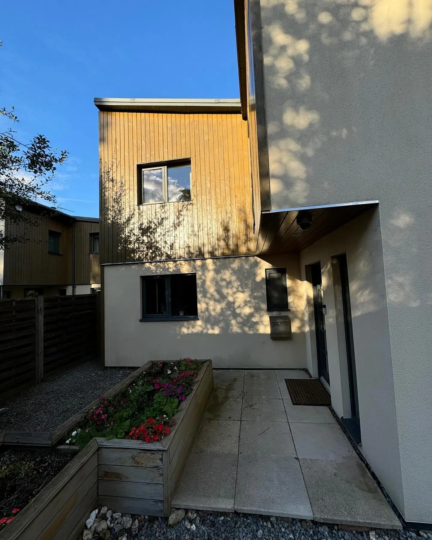 A house that has a planter in front of it.