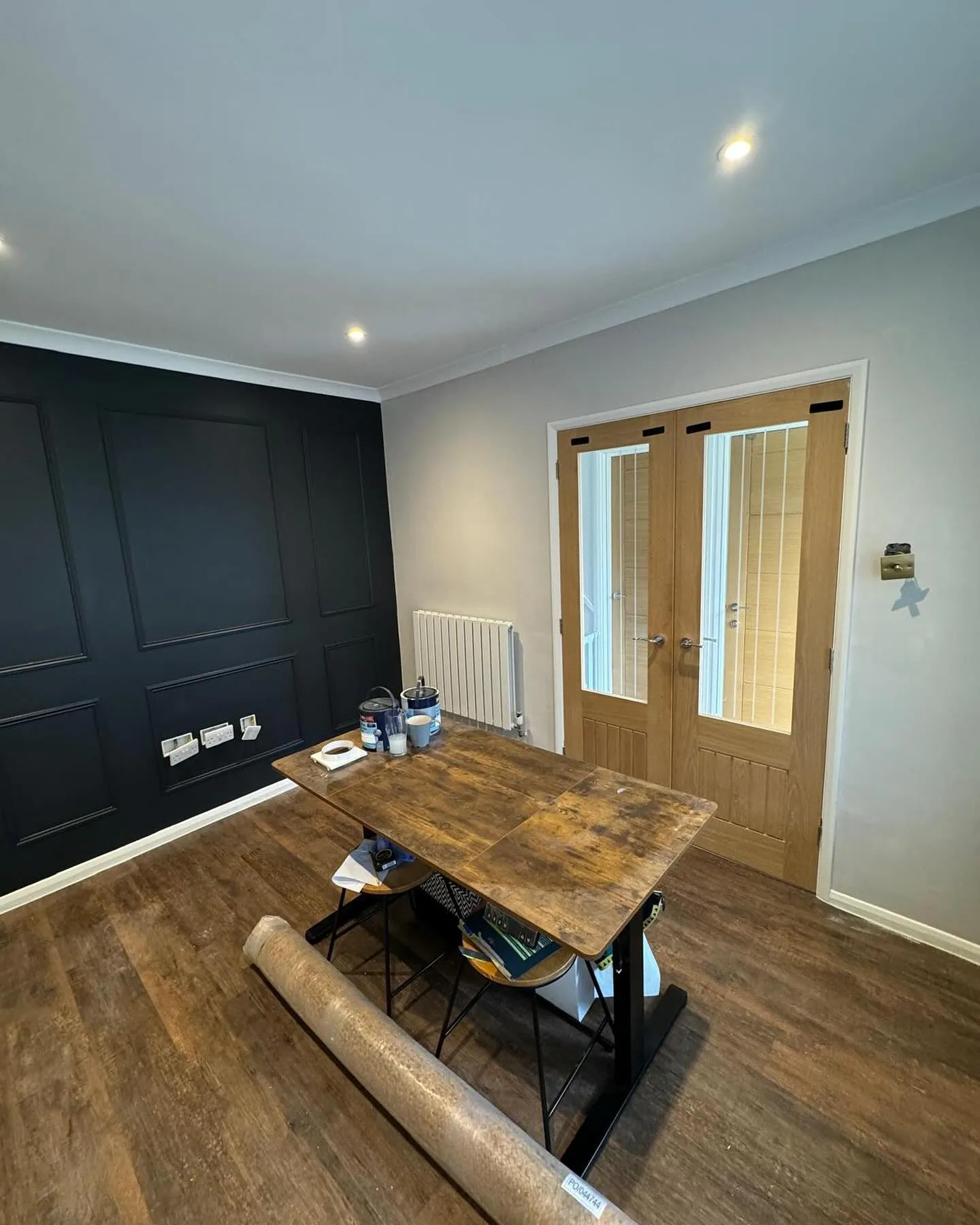 A room with a wooden table and black walls.