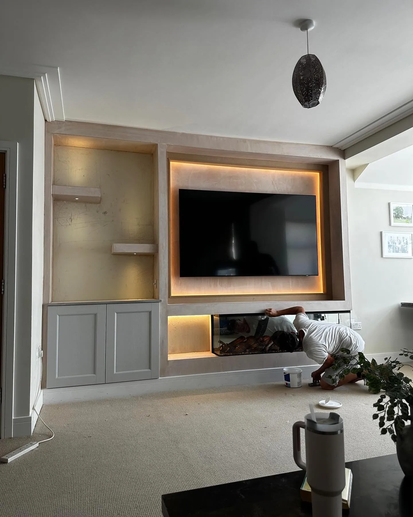 A man laying on the floor in front of a flat screen tv.