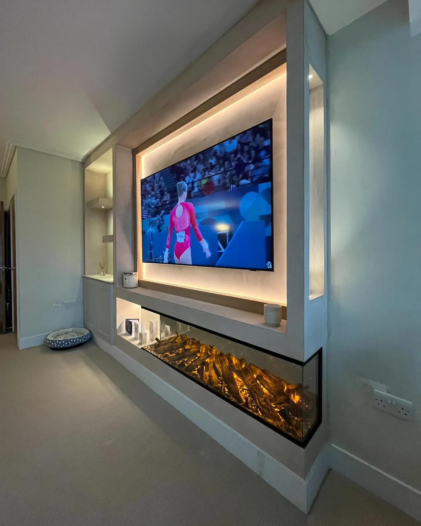 A flat screen tv mounted to a wall in a living room.