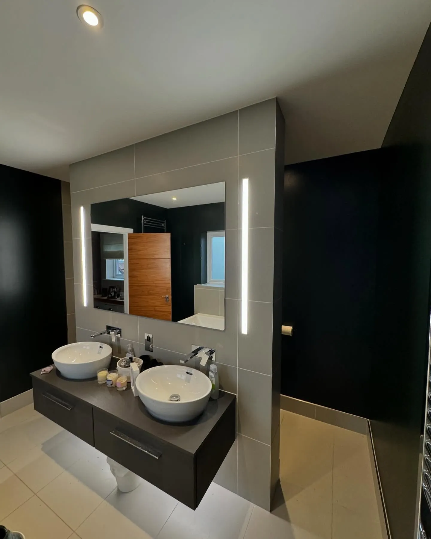 A bathroom with two sinks and a large mirror.