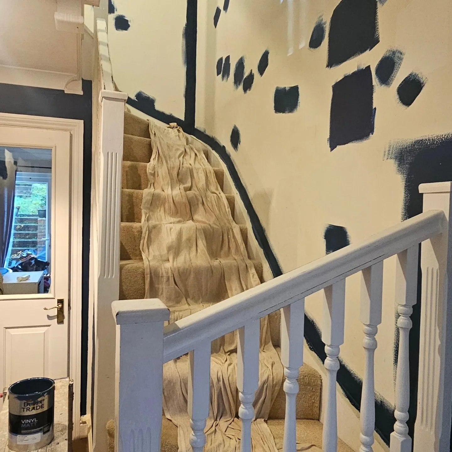A stair case with a painting on the wall.