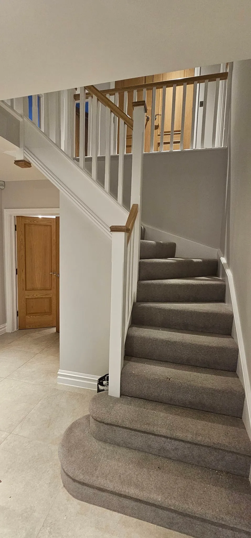 A cat is sitting on the stairs of a house.