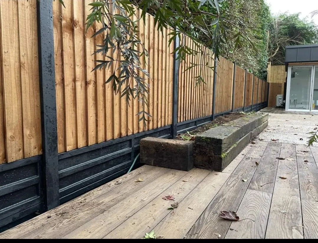 A wooden deck next to a wooden fence.