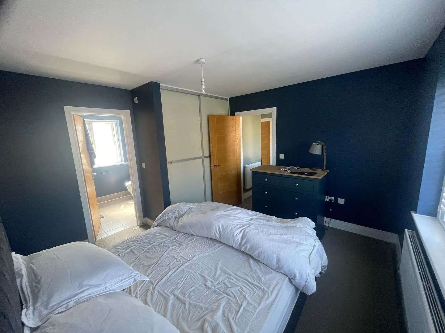 A bedroom with two beds and a dresser.