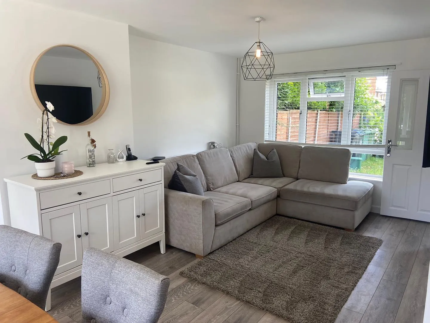 A living room filled with furniture and a large mirror.
