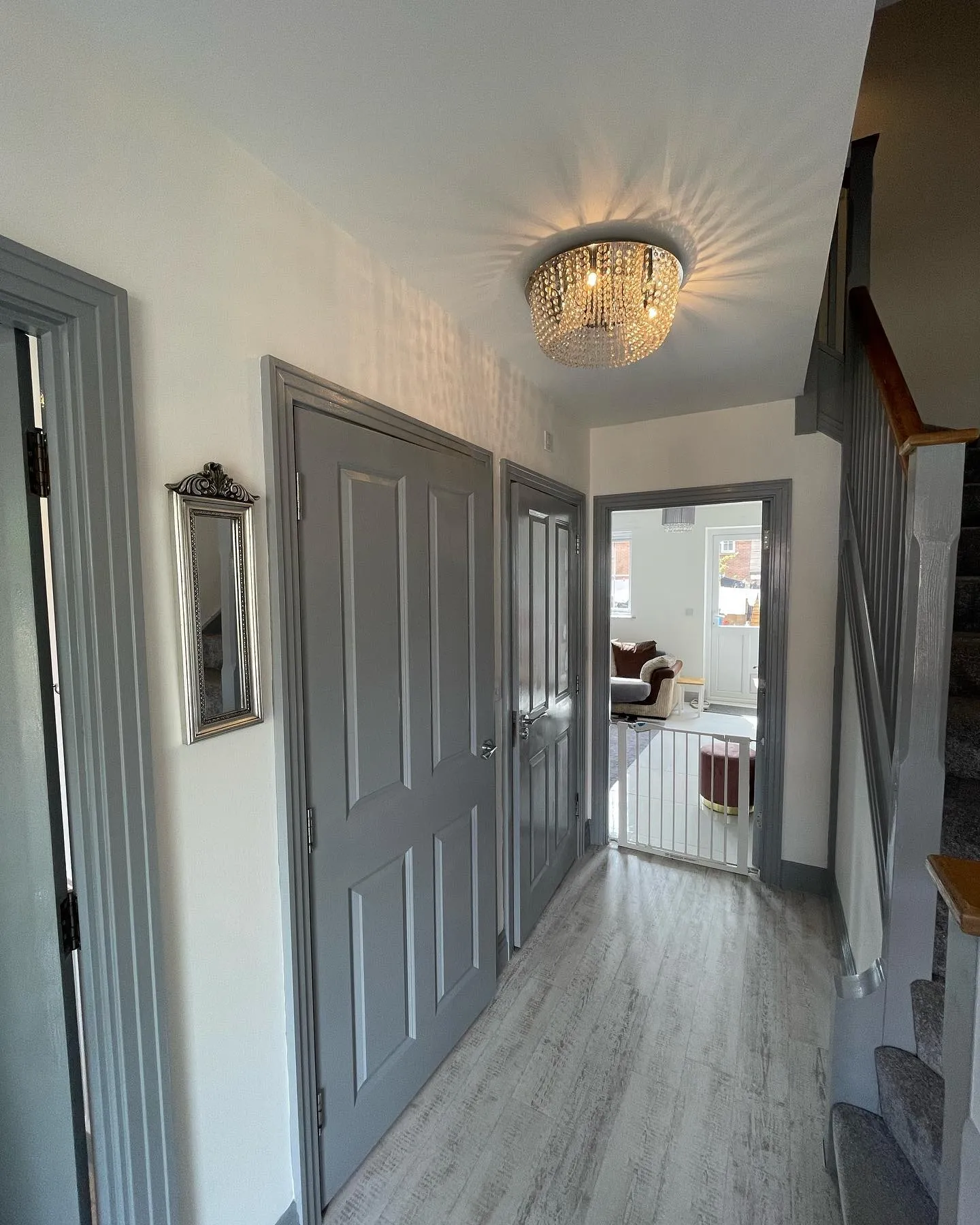 A hallway with a chandelier and two doors.