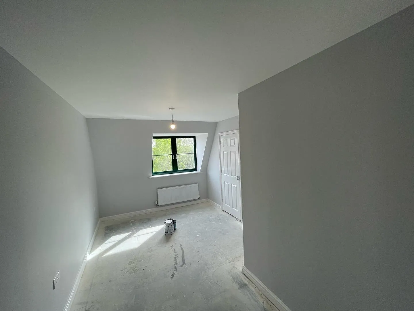 An empty room with a radiator and a window.