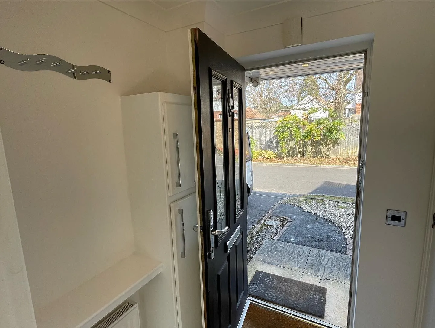 An open door leading to a white house.