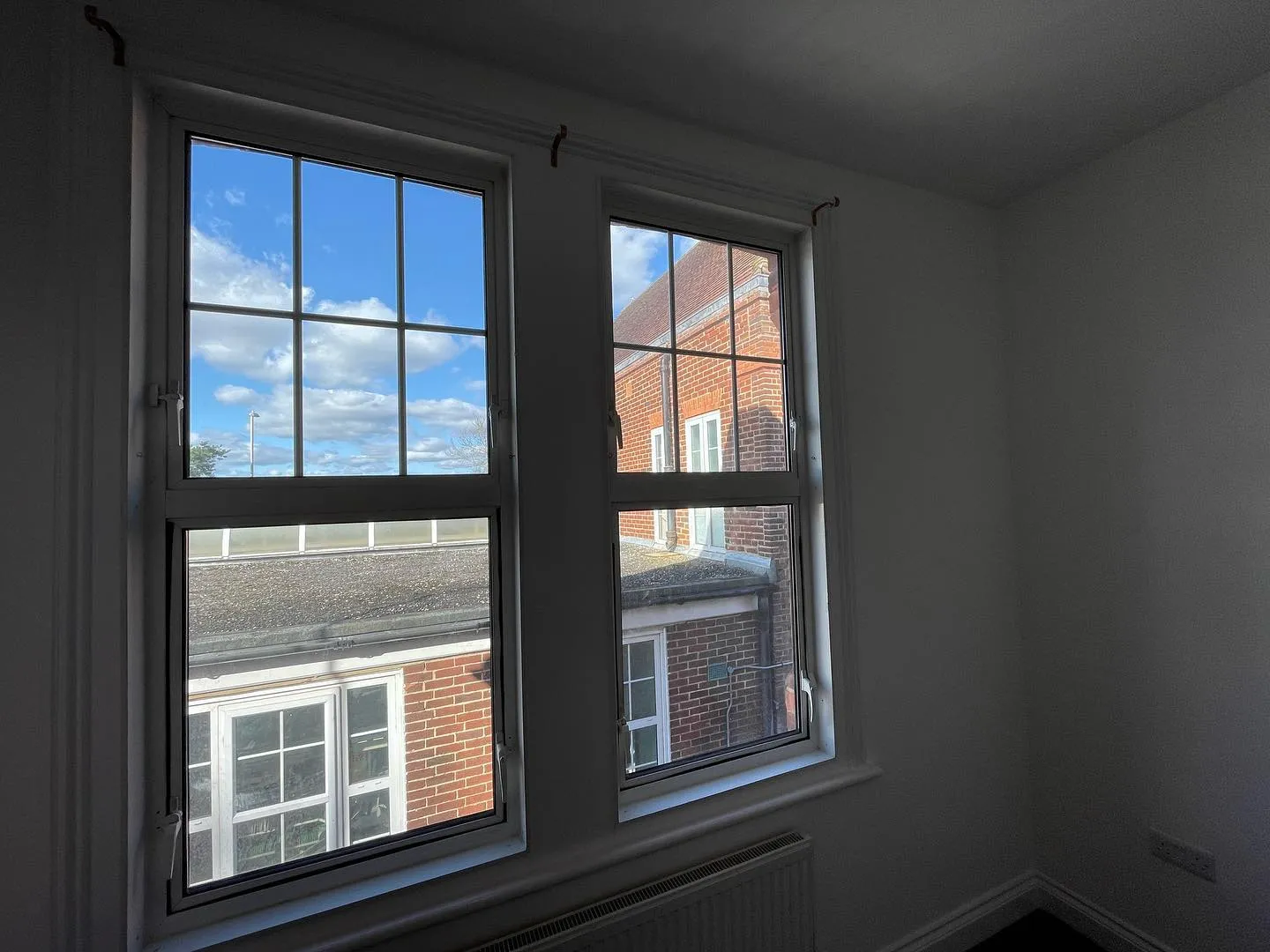 A room with two windows and a sky view.