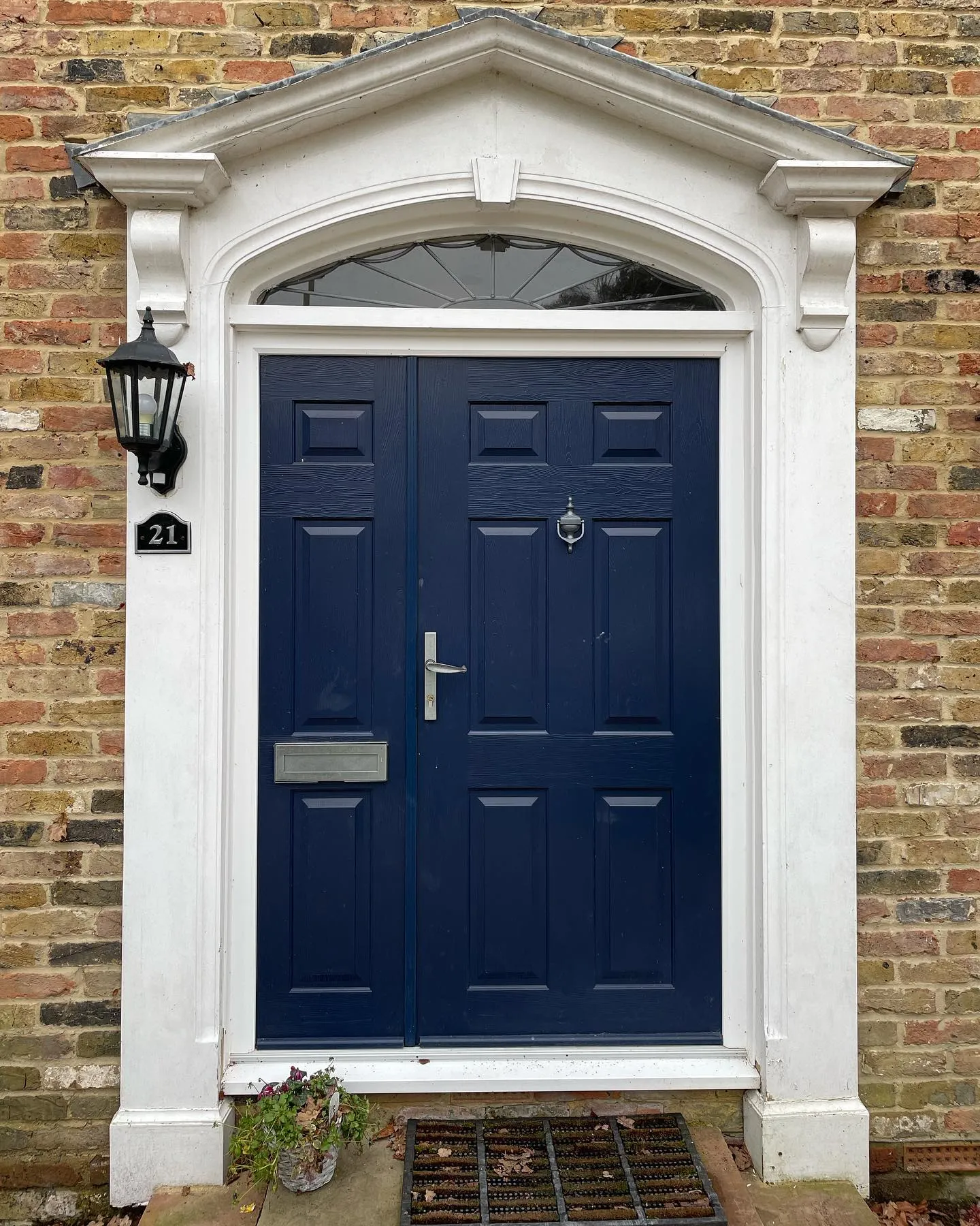 A blue front door on a brick building.
