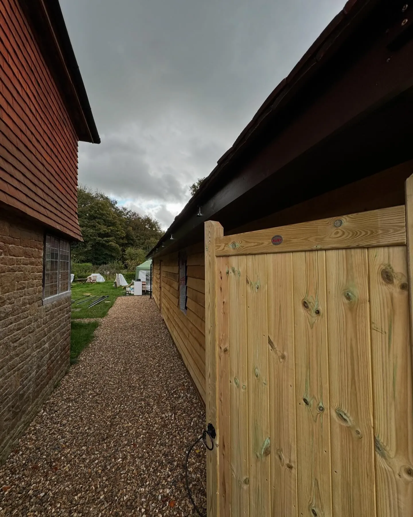 A wooden fence next to a brick building.