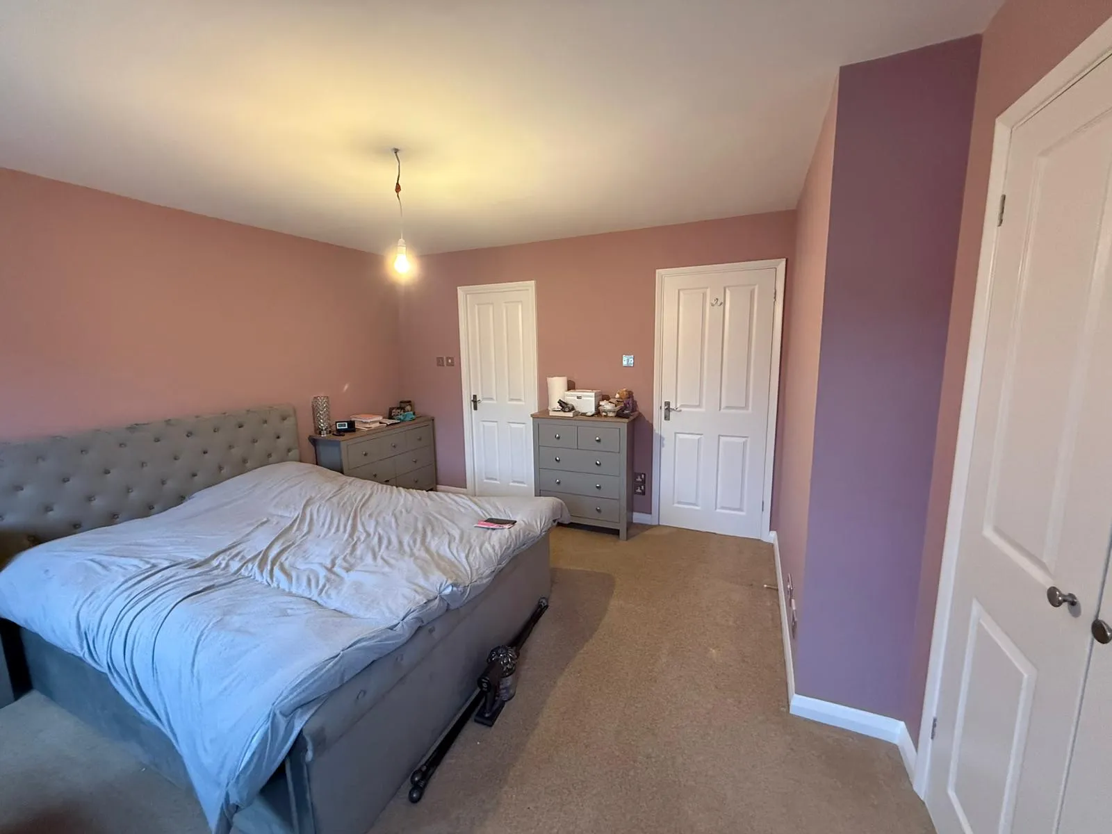 A bedroom with a bed and a dresser.